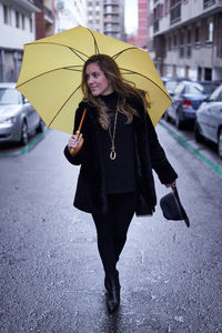 Rear view of woman with umbrella standing on field