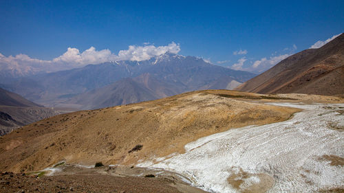 Scenic view of snowcapped mountains against blue sky