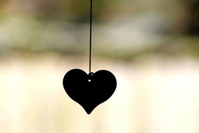 Close-up of heart shape decoration hanging against blurred background