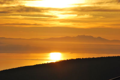 Scenic view of silhouette mountains against romantic sky at sunset