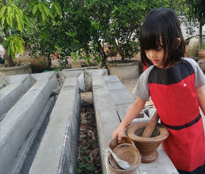 Cute girl holding container on concrete wall