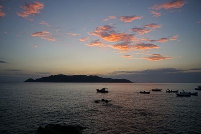 Boats in sea at sunset