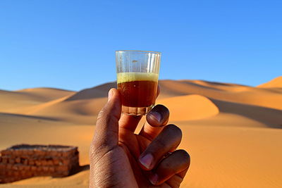 Close-up of hand holding drink glass