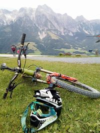 Motorcycle on field by mountains against sky