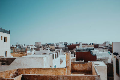 Buildings in city against clear blue sky