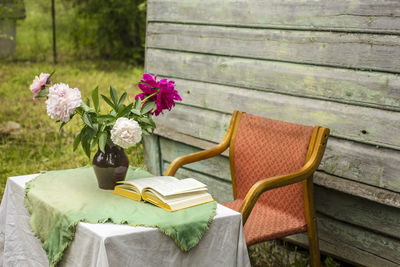 Flower vase on table by bench