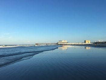 Scenic view of beach against blue sky