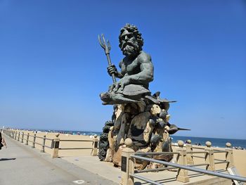 Low angle view of statue against clear blue sky