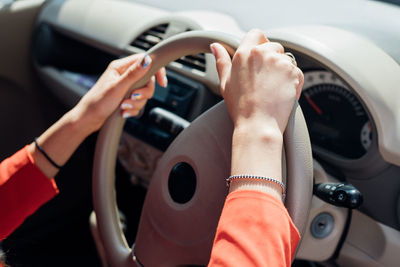 A young woman is sitting at the wheel of a car.hands on the steering wheel close-up.