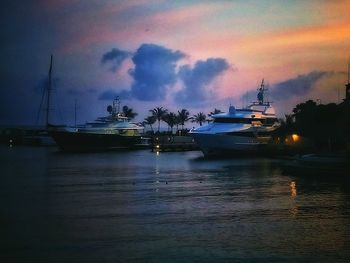 Boats in sea at sunset