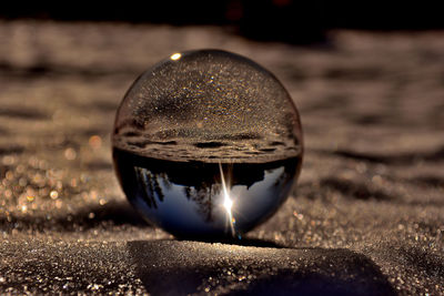 Close-up of crystal ball on sand