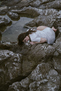 Full length of woman relaxing on rock formation