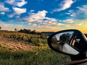 View of side-view mirror against sky