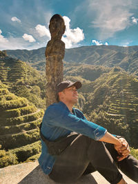 Portrait of man with arms raised on mountain