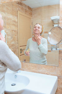 Elderly woman taking care of her face