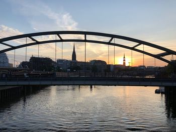 Bridge over river against sky during sunset