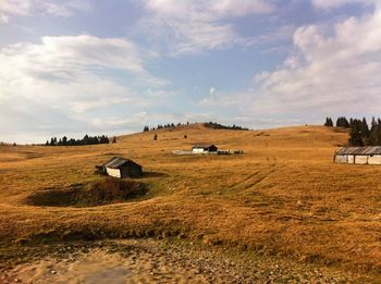 Hay bales on field against sky