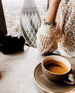 Low section of woman with coffee cup