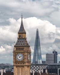 Low angle view of clock tower against cloudy sky