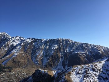 Scenic view of snowcapped mountains against clear blue sky