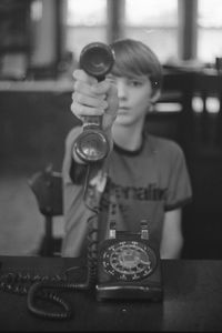 Portrait of boy holding telephone at home