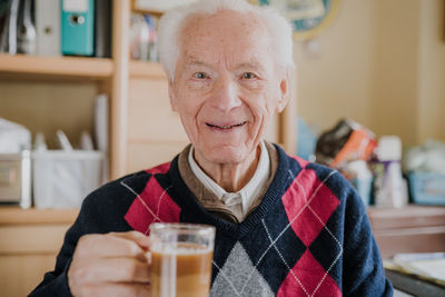 Portrait of smiling man drinking glass