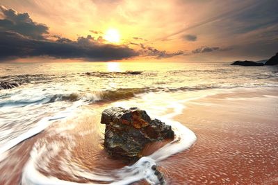 Scenic view of beach against sky during sunset
