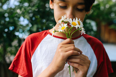 Midsection of woman holding flower