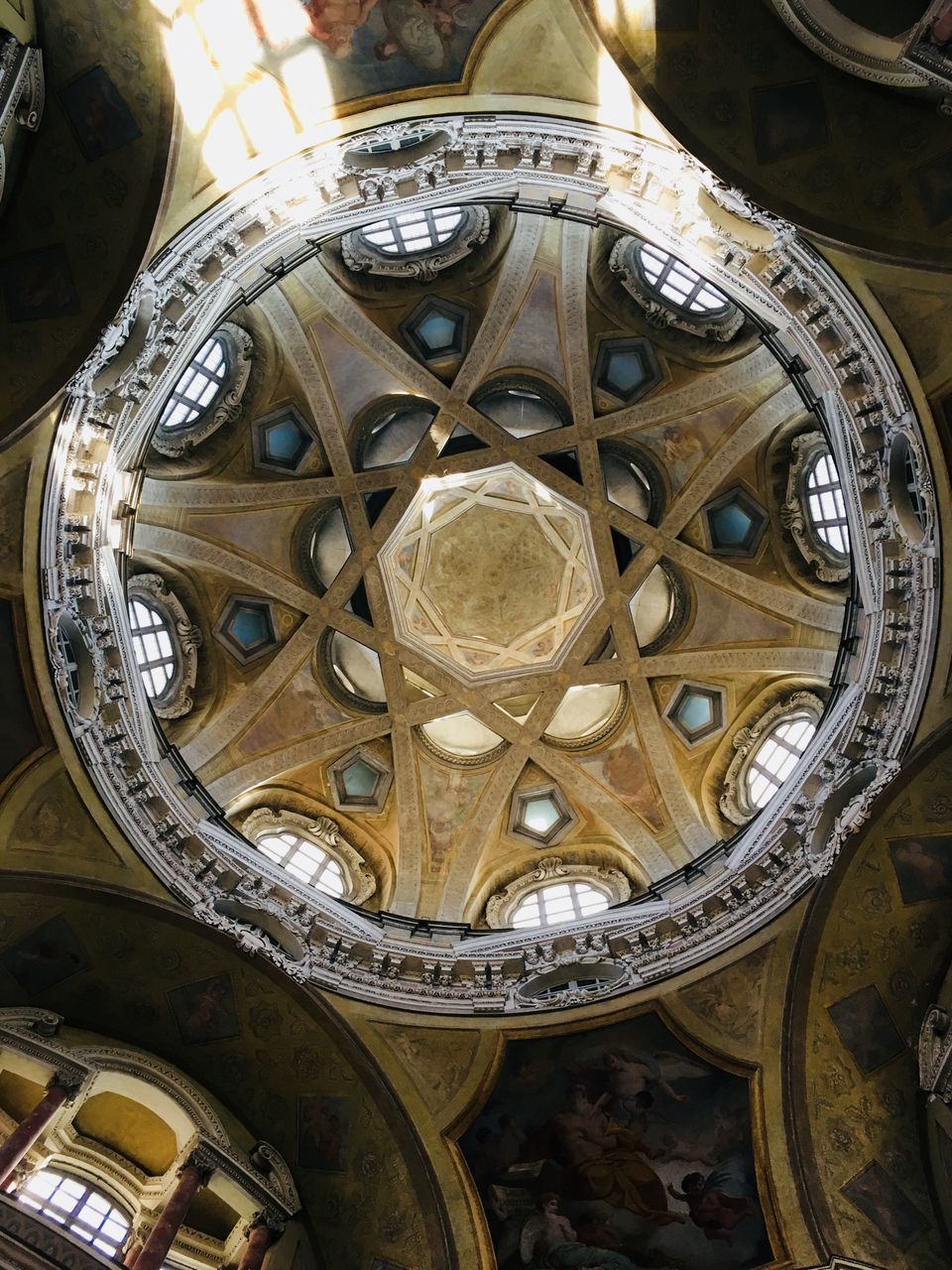 LOW ANGLE VIEW OF ORNATE CEILING IN ILLUMINATED BUILDING