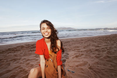 Portrait of young woman standing at beach