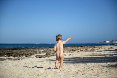 Full length of shirtless boy on beach