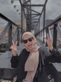 Portrait of young woman wearing sunglasses standing outdoors