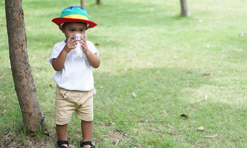 Boy drinking water in park