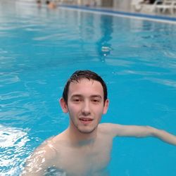 Portrait of shirtless man swimming in pool