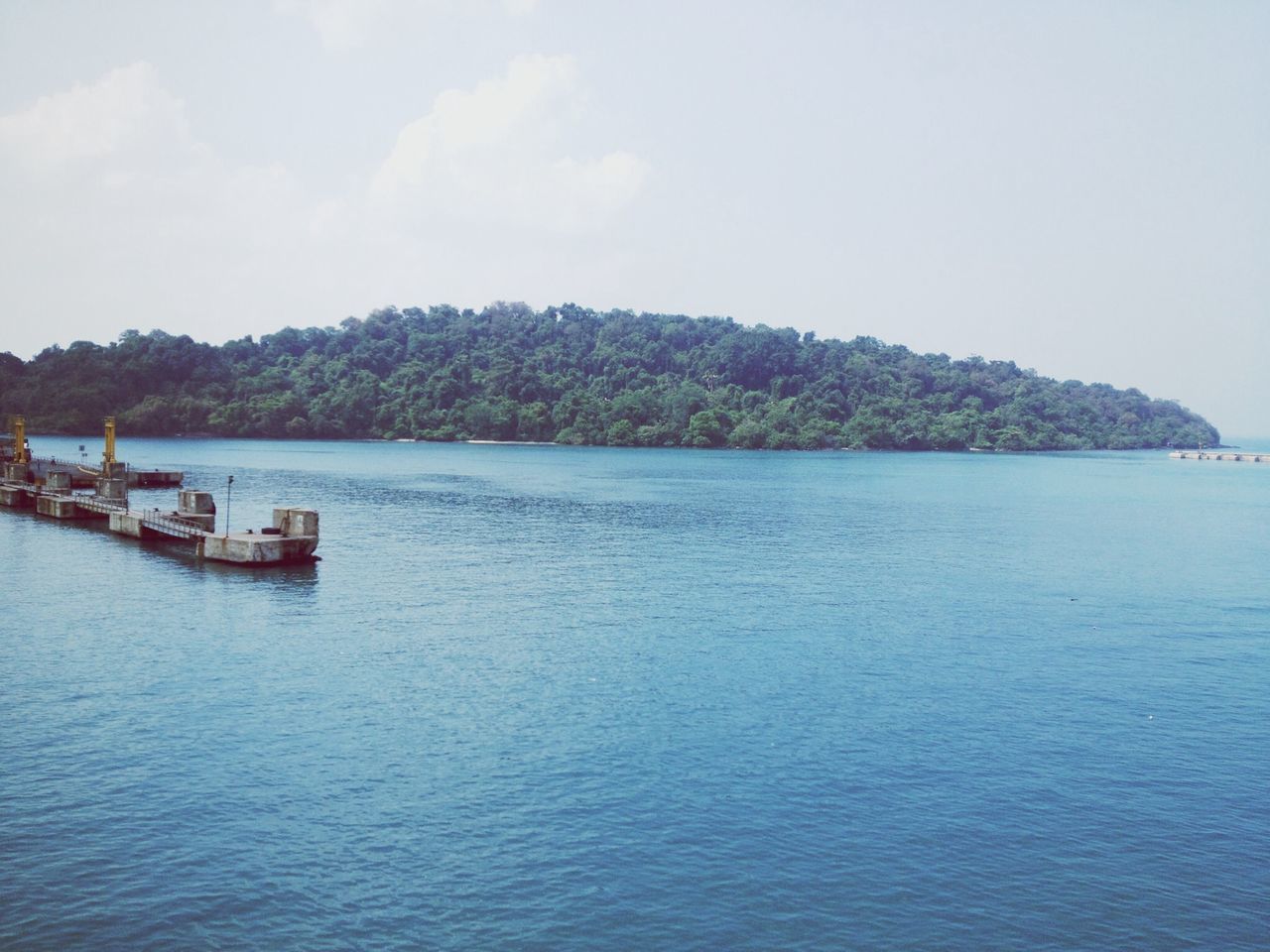 water, sea, nautical vessel, tranquil scene, tranquility, waterfront, scenics, boat, sky, transportation, beauty in nature, nature, mountain, mode of transport, rippled, tree, idyllic, blue, day, horizon over water