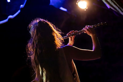 Rear view of woman playing at night