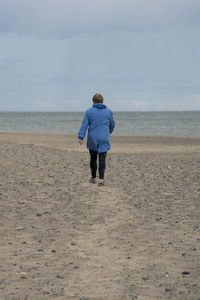 Rear view of man walking at beach