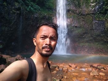 Portrait of man against waterfall