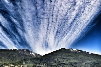 Scenic view of mountains against cloudy sky