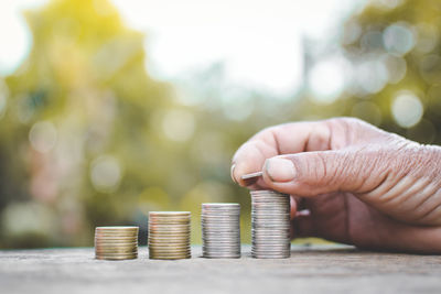 Cropped image of hand stacking coins on table