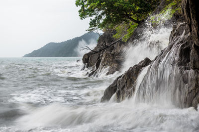 Scenic view of waterfall against sky