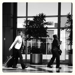 Man and woman walking on palm tree in city