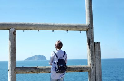 Rear view of woman looking at sea against sky