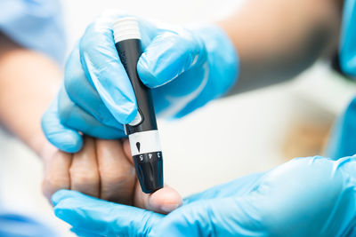 Midsection of doctor holding dental equipment