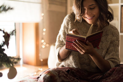 Young woman sitting on book