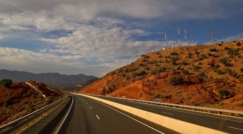 Road by mountain against sky