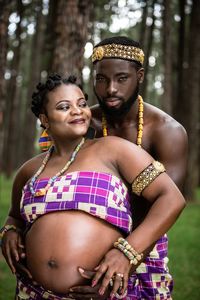 Portrait of young couple standing against tree