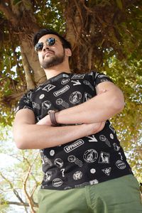 Portrait of man wearing sunglasses standing against tree