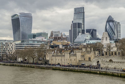 Buildings in city against cloudy sky