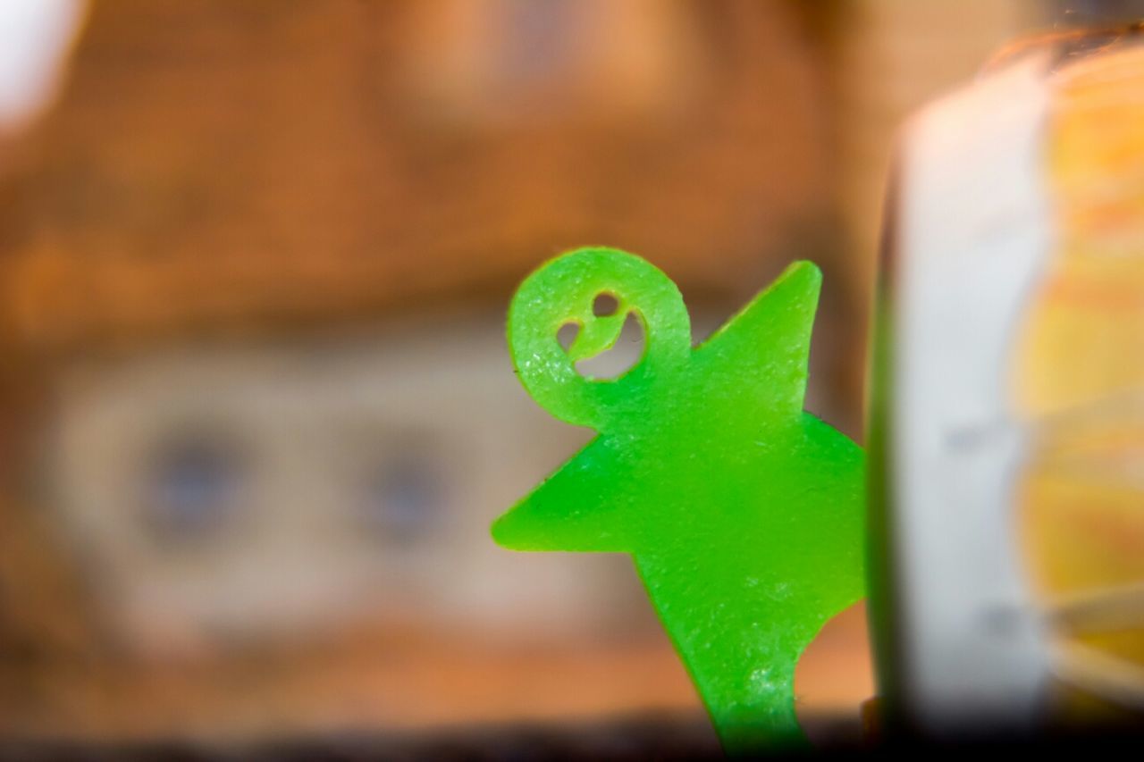 close-up, focus on foreground, art and craft, green color, selective focus, creativity, art, human representation, multi colored, toy, animal representation, no people, day, indoors, yellow, wall - building feature, metal, blue